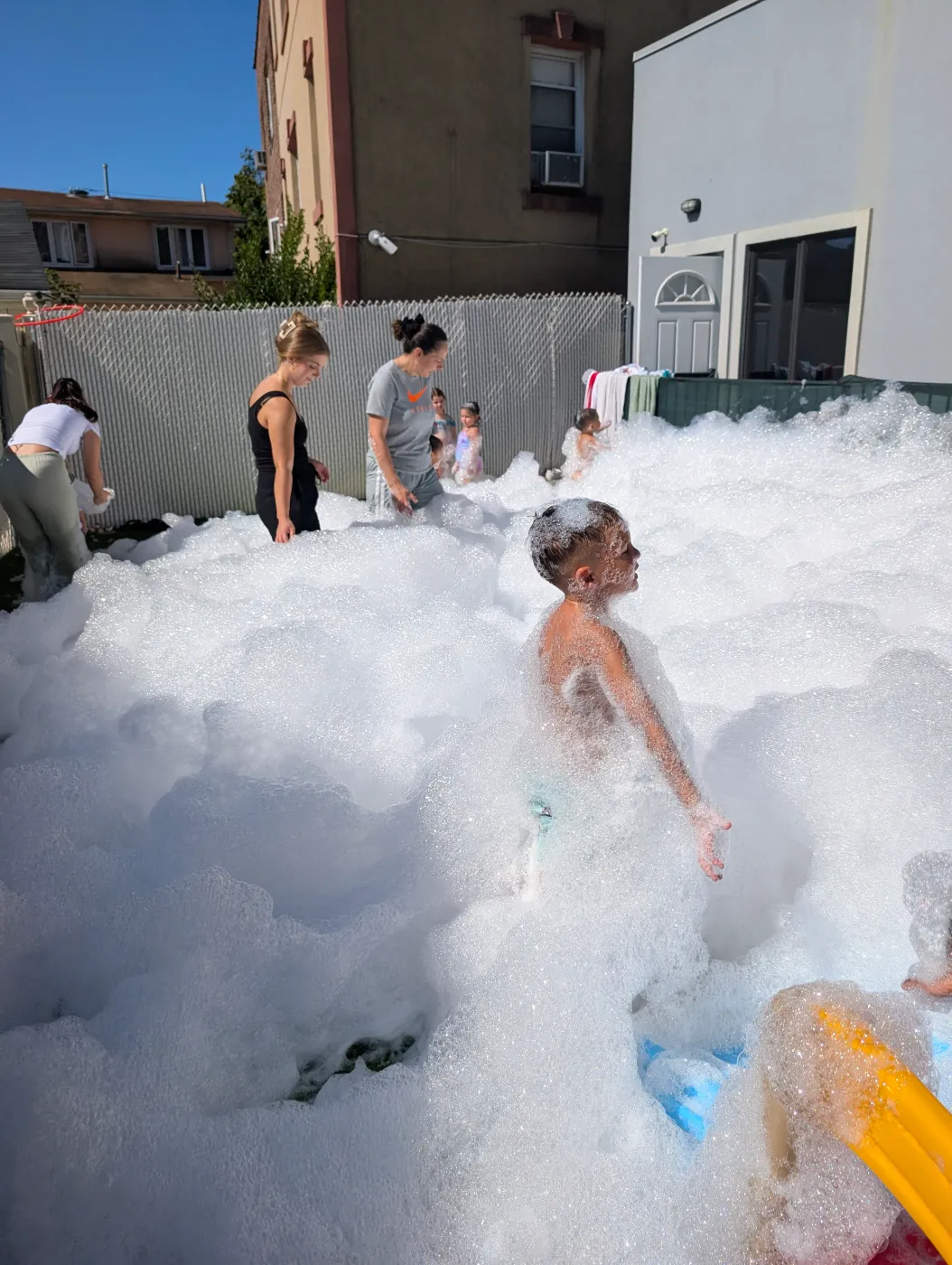 Guests playing in foam in a backyard